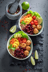 Healthy Mexican salad with groats, meatballs, vegetables and limes.