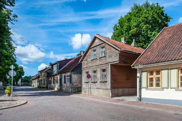 Fototapeta na wymiar View of the street in Kuldiga with old wooden house and stone road. An example of wooden architecture from the 18th century. Latvia.