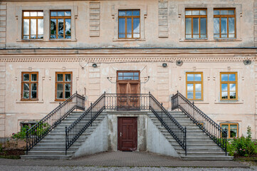 Staircase with metal wrought iron railings. Entrance group in mansion and shabby facade. Spares manor in Latvia, Baltic.