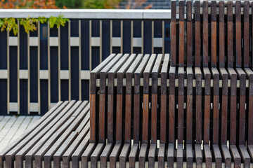 A modern wooden bench in a city. City improvement, urban planning, public spaces. Modern urban architecture