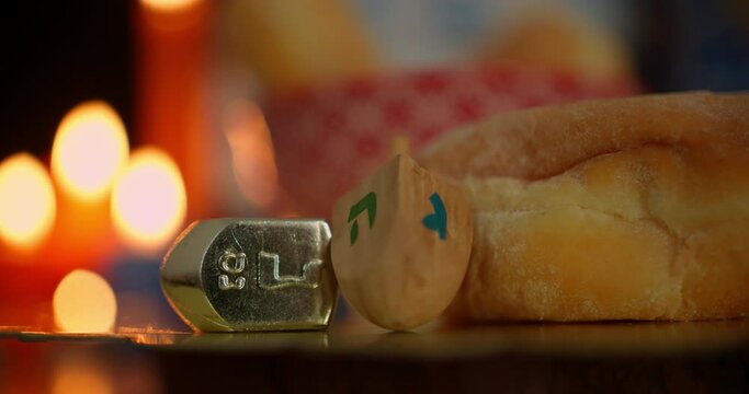 Hanukkah food and dreidels in candlelight