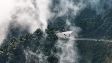 Aerial view of motorcycle rider and curvy road on the  mountains