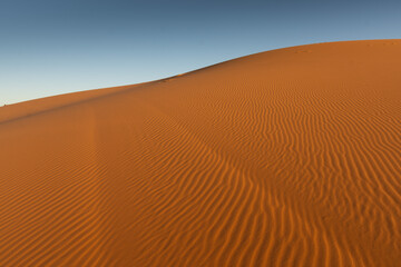 Fototapeta na wymiar Sand ripples in contrasting colors with the sky in the Mezouga desert.
