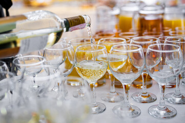 waiter pouring wine from bottle into a glass in cafe or restaurant