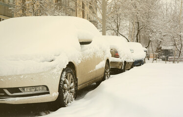 Fragment of the car under a layer of snow after a heavy snowfall. The body of the car is covered with white snow