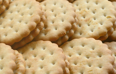 Detailed picture of round sandwich cookies with coconut filling. Background image of a close-up of several treats for tea