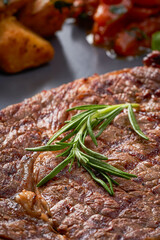 Close-up of a steak dish with potatoes and grilled vegetables With rosemary