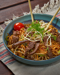 Close-up of a bowl of noodles with beef with herbs