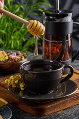 Traditional Turkish tea cup with copper and glass utensils and herbs with honey