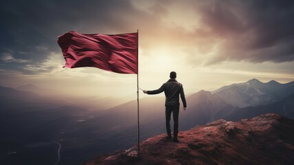 Silhouette of a person on a top of mountain with red flag and sky background.
