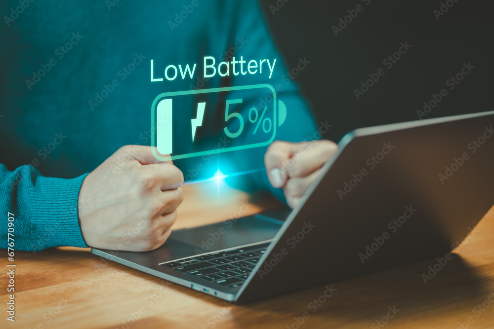 Poster Laptop out of battery. Concept of Technology and daily life. Man is angry and frustrated when he learns that his laptop computer's battery is dead and did not bring the charger adapter.