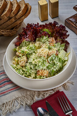 Chicken Caesar salad plate on a wooden floor