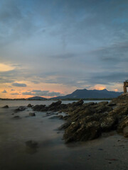 Fototapeta premium panoramic view of a rocky beach at sunset