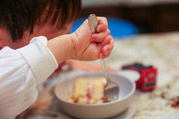 baby's chubby arms grasping a spoon, eating nutritious baby food, symbolizing essential child...