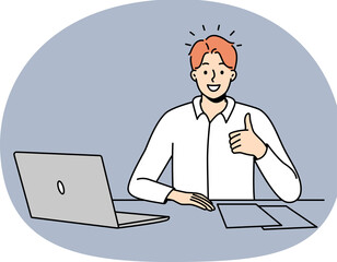 Smiling man at office desk show thumb up