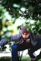 Bearded man blends in, perched on tree, observing urban scenery.