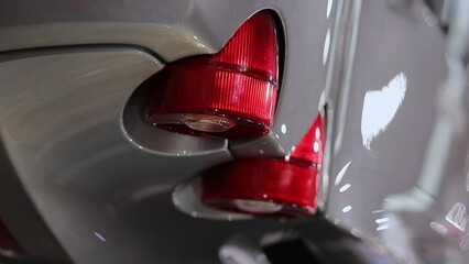 rear lights of a sports car. Large red round tail lights of a racing modern sports car. round red tail lights of a modern sports car. round tail lights of a gray sports car. vertical orientation video