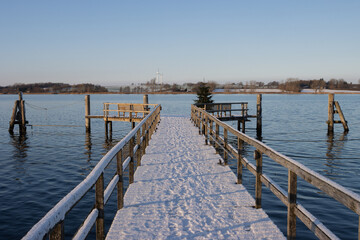 Naklejka premium Schneebedeckter Steg am Hefen von Sieseby mit Blick auf die Schlei im Winter.