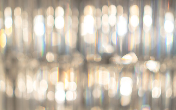 Blur golden bokeh background of blurry luxury crystal ball chandelier for reflective glittering light from Christmas holiday party
