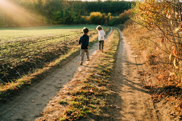 Little happy boys twins running countryside road. Rural childhood, autumn,family