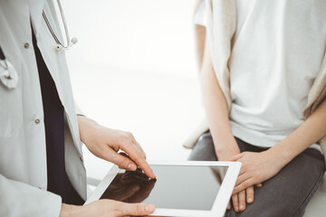 Doctor and child patient. The doctor is using tablet computer and is ready to examine the boy. The concept of ideal health in medicine