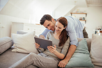 Fototapeta premium Young couple using tablet together at home
