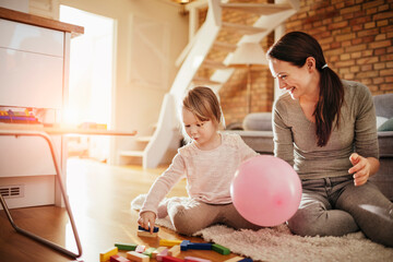 Mother and Daughter Playing with Building Blocks on a Cozy Living Room Floor