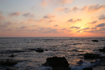 Fototapeta na wymiar Sunset on the background of a rocky beach