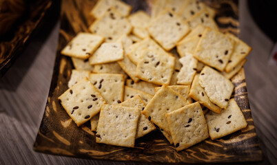 Cookies with scattered seeds in a beautiful wooden plate.
