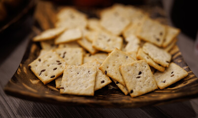 Cookies with scattered seeds in a beautiful wooden plate.