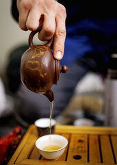 Fototapeta na wymiar Tea pouring from a teapot into a mug. Tea ceremony