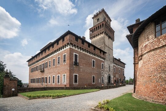 Rustic brick structure situated in a scenic Italian castle grounds, surrounded by lush greenery