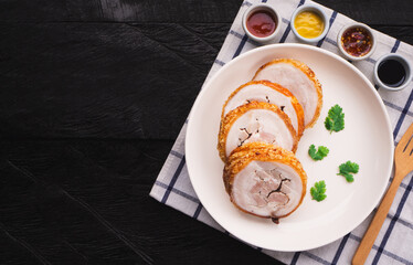 Top view of homemade chashu crispy pork belly in plate on wooden table background.