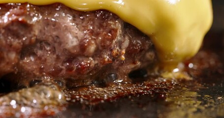 Macro shot of frying beef halal cutlets with melted cheese on top. Cinematic advertisement burger cooking. Making cheese burger, traditional cooking. Halal beef cutlets being fried to perfection