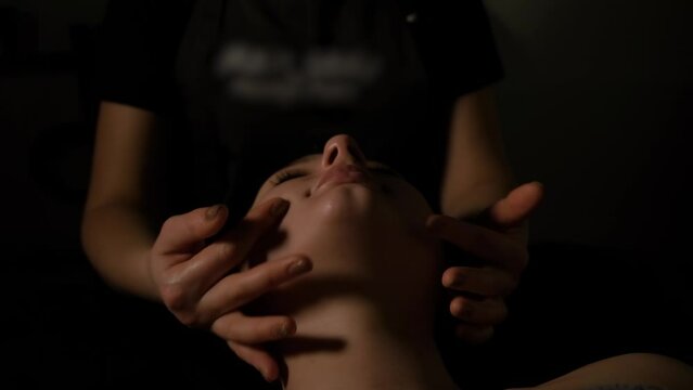 The woman is receiving a chin massage.