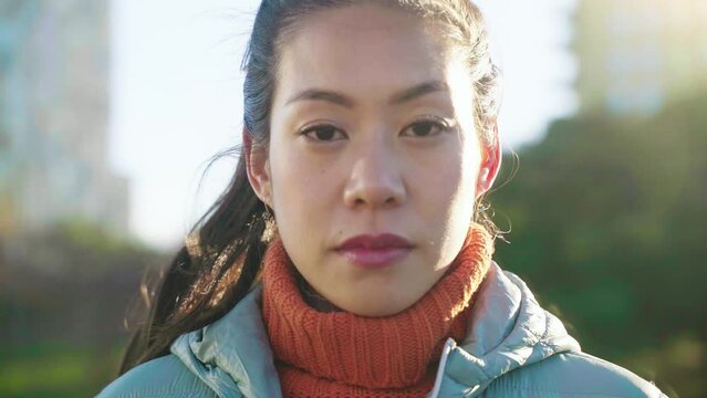 Portrait of an attractive Asian Chinese woman looking at camera. High quality 4k footage