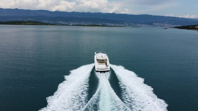 A drone is chasing a fast-moving motor yacht at high speed. Drone shot of a motor yacht at sea