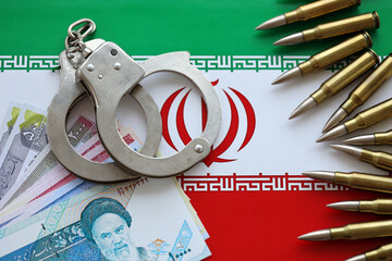 Iran flag and police handcuffs with iranian money bills rials. The concept of crime and offenses in...
