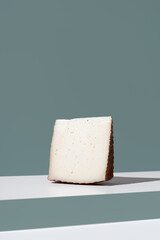 Trozo de queso de cabra curado. Aperitivo español sobre fondo verde