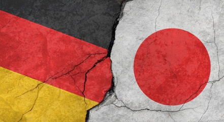 Germany and Japan flags, concrete wall texture with cracks, grunge background, military conflict concept