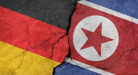 Germany and North Korea flags, concrete wall texture with cracks, grunge background, military conflict concept