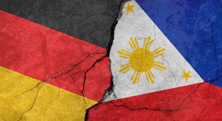 Germany and Philippines flags, concrete wall texture with cracks, orange background, military conflict concept