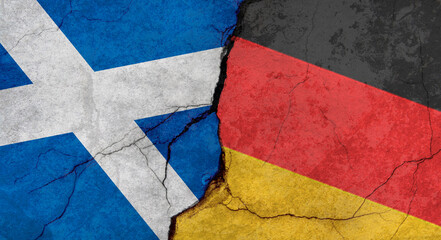 Scotland and Germany flags, concrete wall texture with cracks, grunge background, military conflict concept