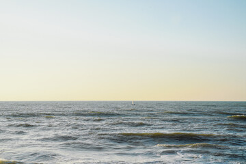 Obraz premium A sailboat sails against a sunset in the Mediterranean Sea