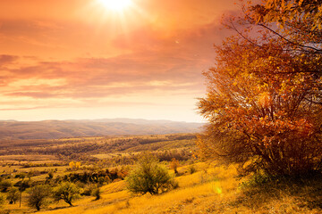 Herbstlandschaft mit Hügelkette m Hintergrund und Sonnenlicht