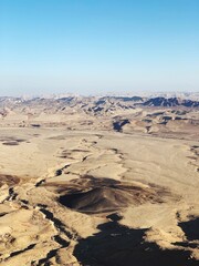 Fototapeta na wymiar Vertical shot of desert landscape, sand dunes and terrain on a sunny day in Tel Aviv