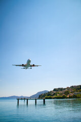 an airplane approaching Corfu town, close to the sea