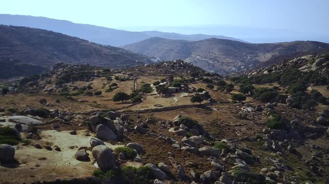Drone footage of abandoned stone houses on a sunny day in Volax village, Tinos Island, Greece