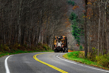 A logging truck transporting cut trees rounds the curve in the rural town of Windsor in Upstate NY....