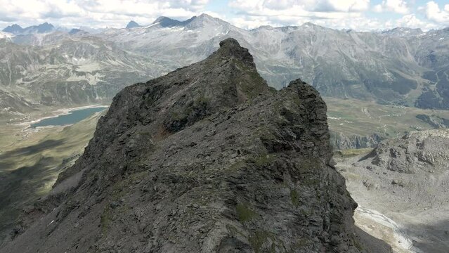 Drone zooming out on a scenic rocky peak crest in Val Loga Montespluga Italian Alps